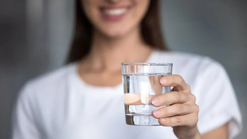 A woman holding a glass of water