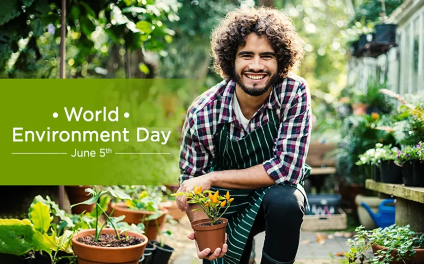 A young happy man holding a plant