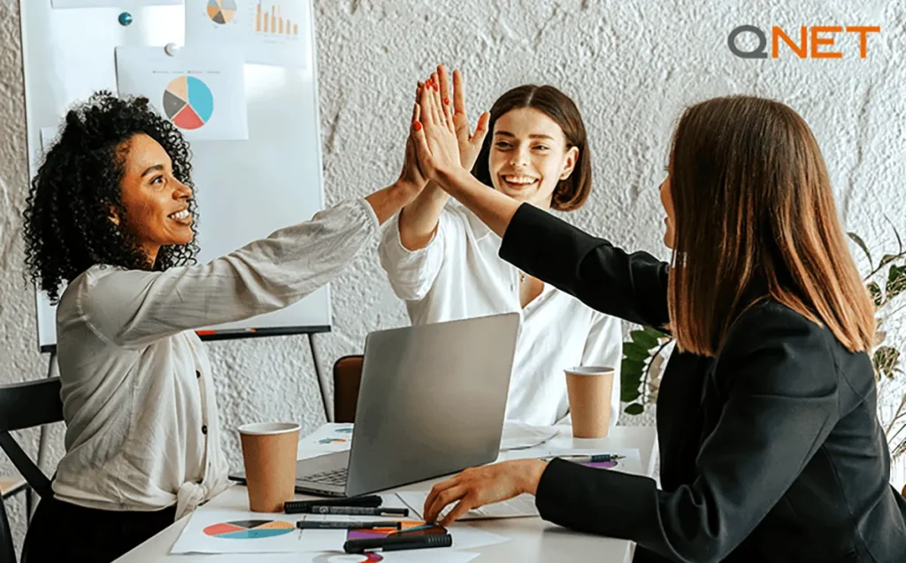 A positive team of entrepreneurs huddling with hands