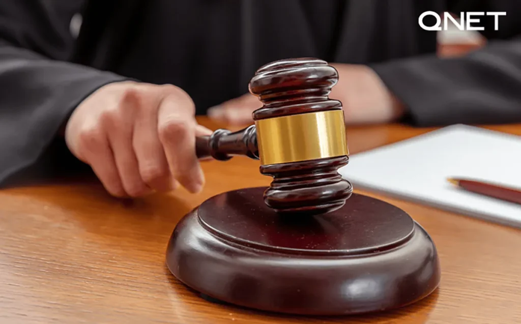 A judge passing a mallet and gavel