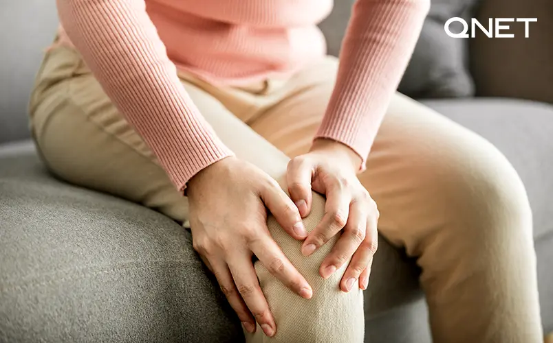 A young woman suffering from Knee pain